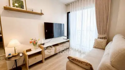 Cozy living room with modern decor and large window offering natural light.
