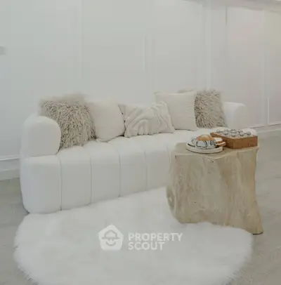 Elegant living room with plush white sofa and rustic wooden coffee table.