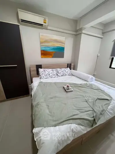 Cozy bedroom with modern decor and air conditioning, perfect for relaxation.