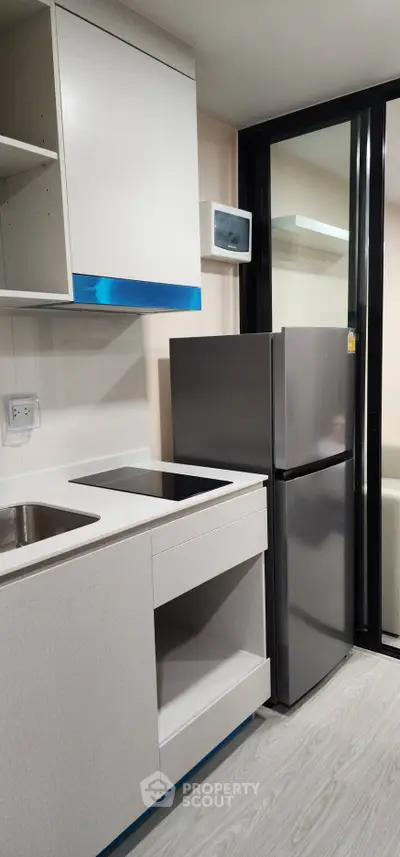 Modern kitchen with sleek cabinetry and stainless steel appliances in a contemporary apartment.