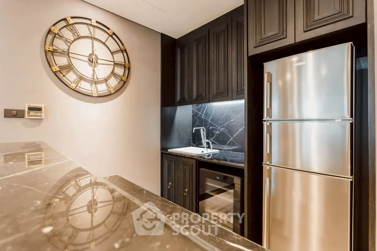 Luxurious kitchen with sleek black cabinetry and modern stainless steel appliances.