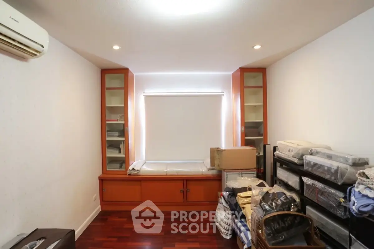 Spacious storage room with wooden flooring and ample shelving space