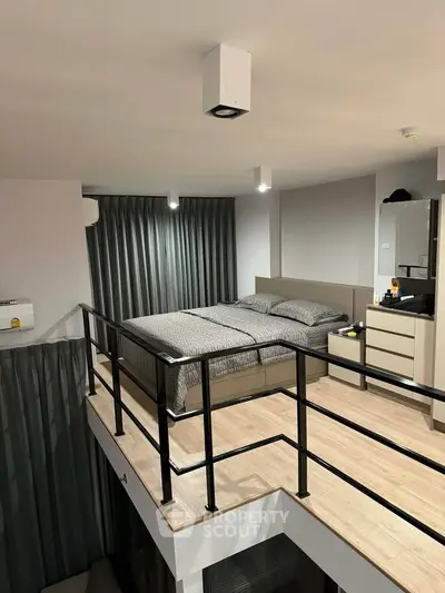 Modern loft bedroom with sleek design and stylish railing overlooking lower level.