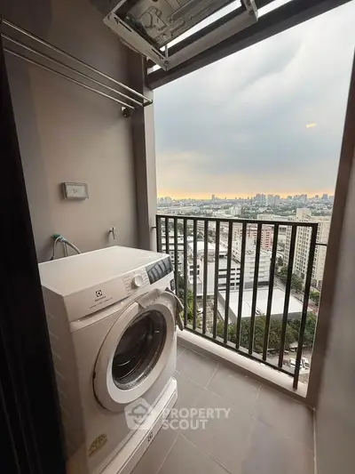 High-rise apartment balcony with washing machine and stunning city view.