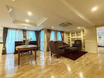 Elegant living room with hardwood floors, cozy seating, and built-in shelves in a spacious layout.