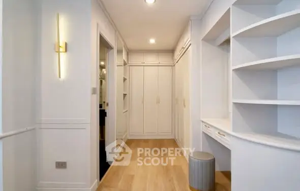 Spacious walk-in closet with elegant built-in storage and modern lighting