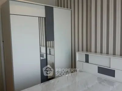 Modern bedroom with sleek wardrobe and stylish striped wallpaper