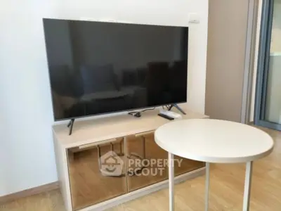 Modern living room with sleek TV stand and round table, perfect for cozy entertainment.