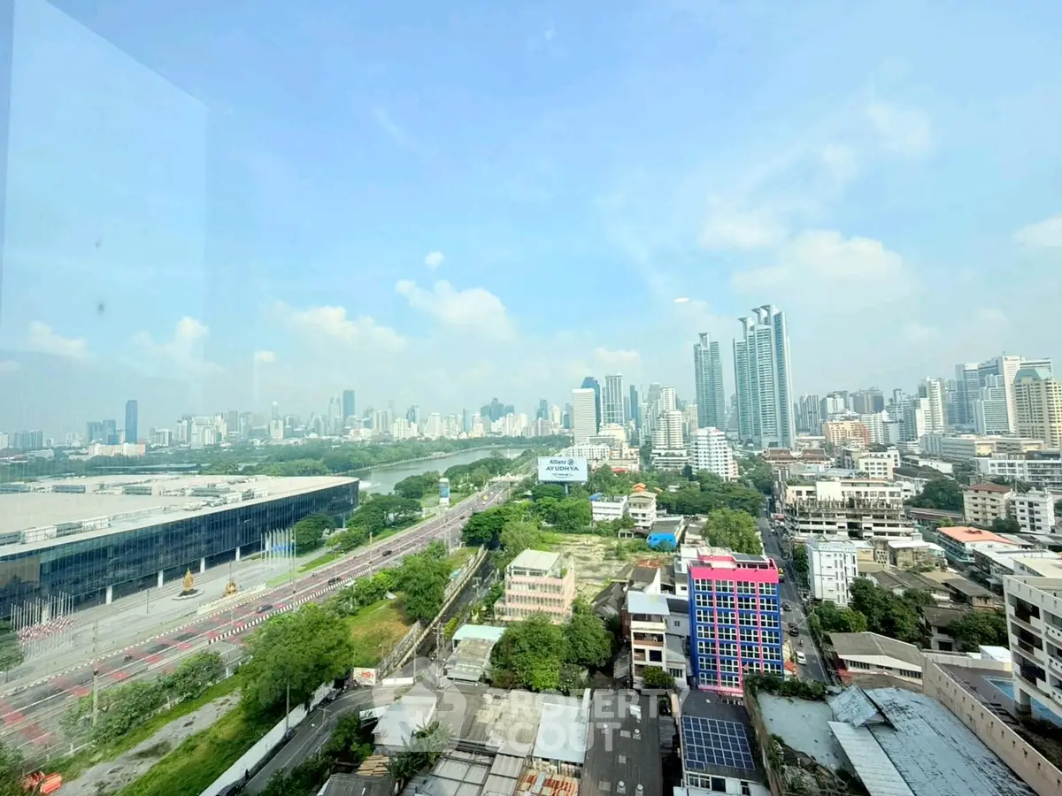 Stunning cityscape view from high-rise building with lush greenery and urban skyline.