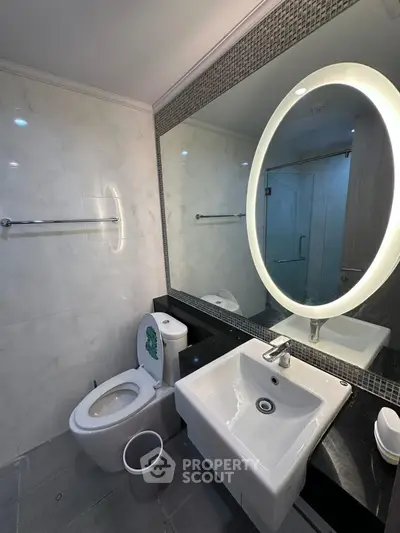 Modern bathroom with illuminated mirror and sleek fixtures