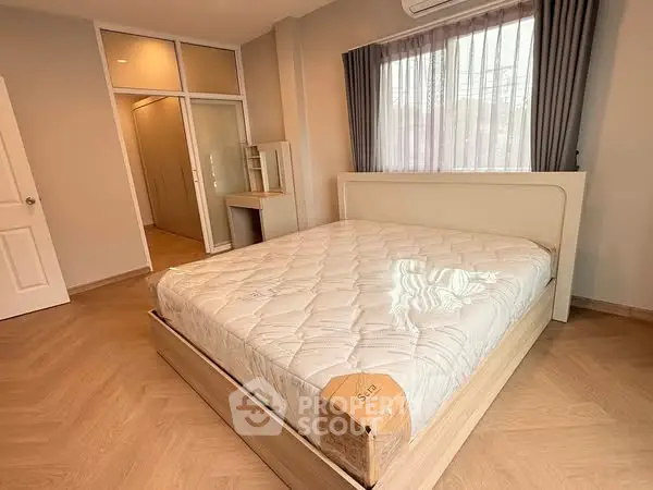 Spacious bedroom with large bed and natural light, featuring modern design and ample storage.