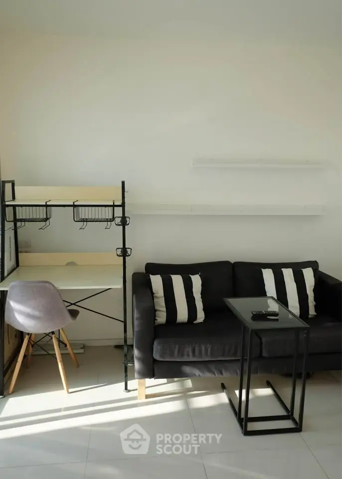 Modern living room with sleek black sofa, stylish desk, and minimalist decor