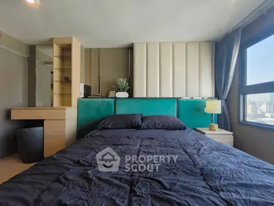 Modern bedroom with city view, featuring stylish decor and natural light.