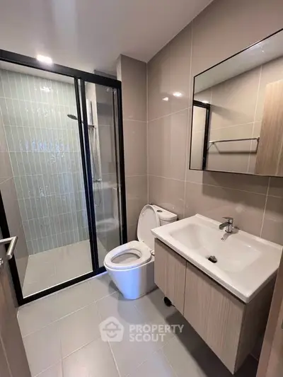 Modern bathroom with sleek design, featuring a glass-enclosed shower and stylish vanity.
