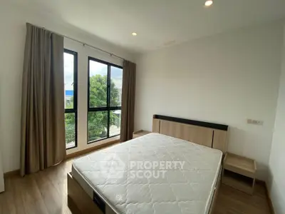 Bright bedroom with large windows and modern wooden furniture