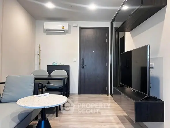 Modern living room with sleek furniture and wall-mounted TV in a stylish apartment.