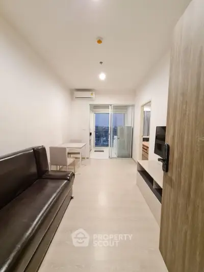 Modern living room with sleek furniture and balcony view in a stylish apartment.