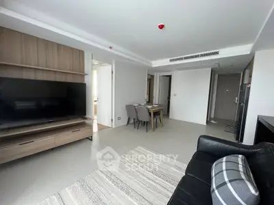 Modern living room with sleek furniture and large TV in a stylish apartment.