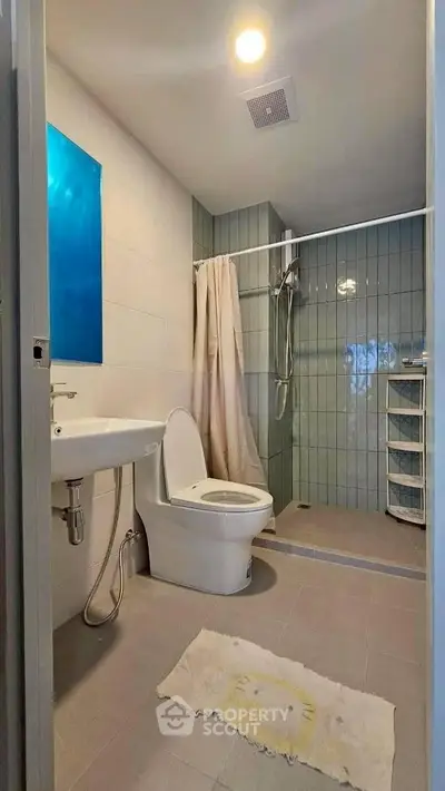Modern bathroom with shower and sleek fixtures in a contemporary apartment.