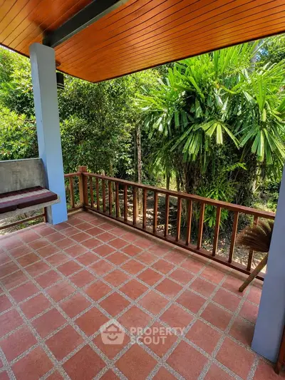 Charming outdoor patio with lush greenery and terracotta tiles, perfect for relaxation and enjoying nature.