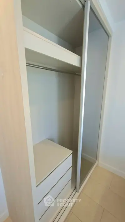 Spacious built-in wardrobe with sliding doors and ample storage in modern apartment.