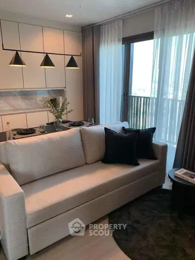 Modern living room with elegant sofa, stylish lighting, and balcony view in a chic apartment.