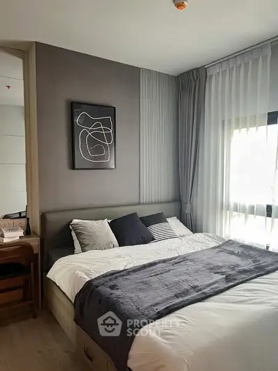 Modern bedroom with stylish decor and natural light, featuring a cozy bed and elegant curtains.