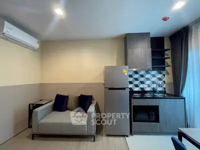Modern apartment interior with compact kitchen and cozy living area featuring sleek design and stylish decor.