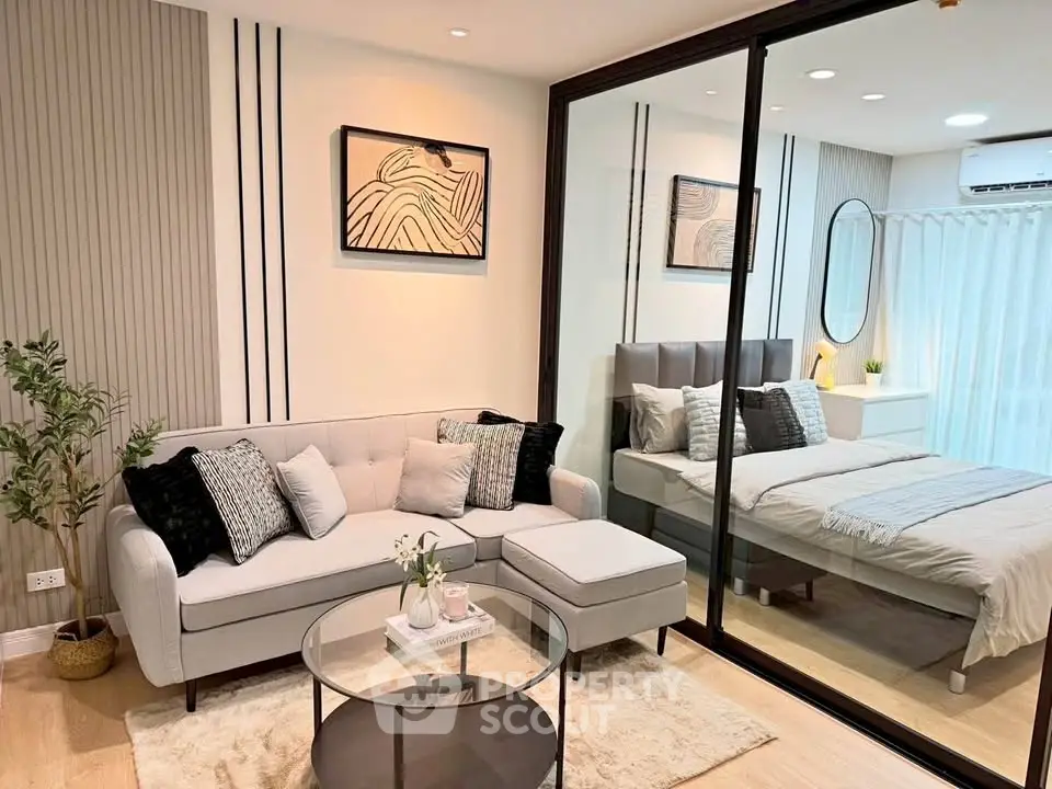 Modern living room with elegant decor and cozy bedroom view through glass partition.