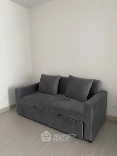 Modern minimalist living room with sleek gray sofa and neutral decor