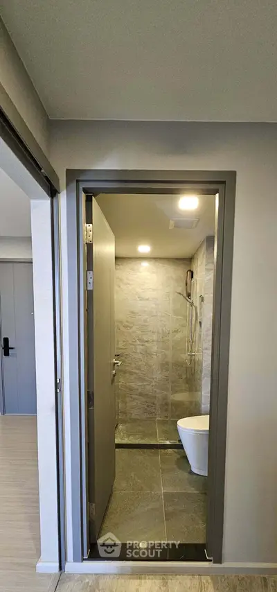 Modern bathroom with sleek design and glass shower enclosure in a contemporary apartment.