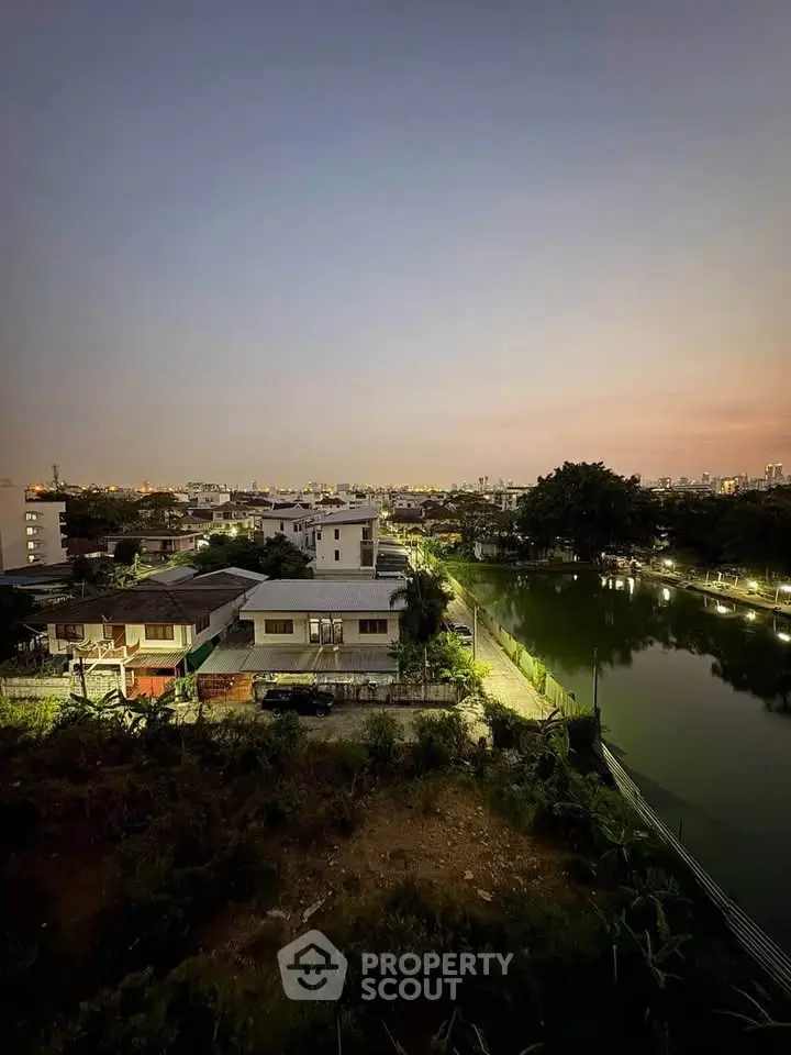 Stunning aerial view of suburban homes by a serene lake at dusk, showcasing tranquil living and scenic beauty.