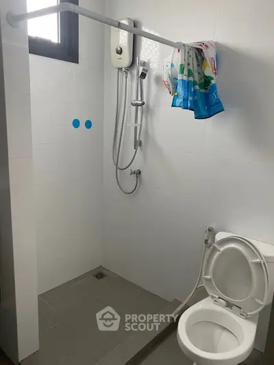 Modern bathroom with shower and toilet in a sleek minimalist design.