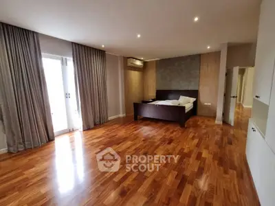 Spacious bedroom with wooden flooring and modern design