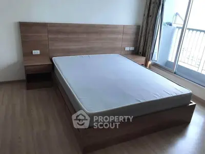 Spacious bedroom with modern wooden bed frame and balcony access