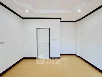 Spacious empty room with elegant ceiling and wooden flooring, perfect for customization.