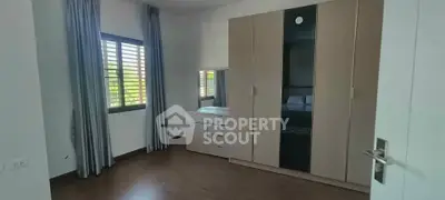 Spacious bedroom with large wardrobe and natural light from window