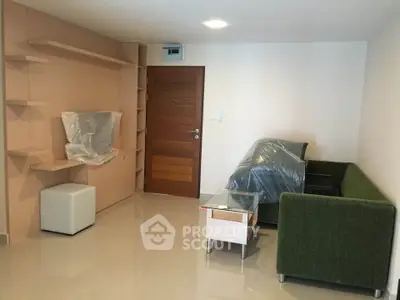 Modern living room with green sofa and wooden door, featuring sleek built-in shelves.