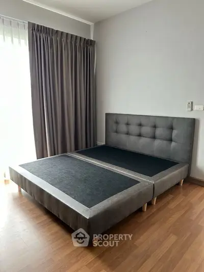 Modern bedroom with stylish bed frame and elegant curtains, perfect for a cozy retreat.