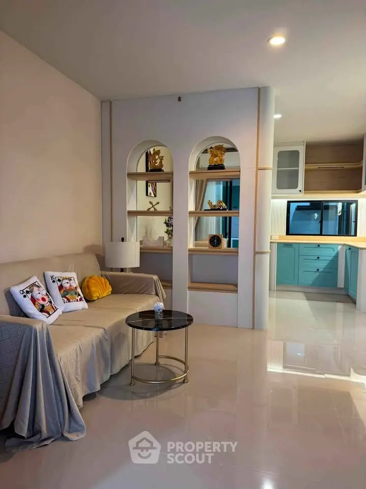 Stylish living room with modern decor and open kitchen layout, perfect for contemporary living.