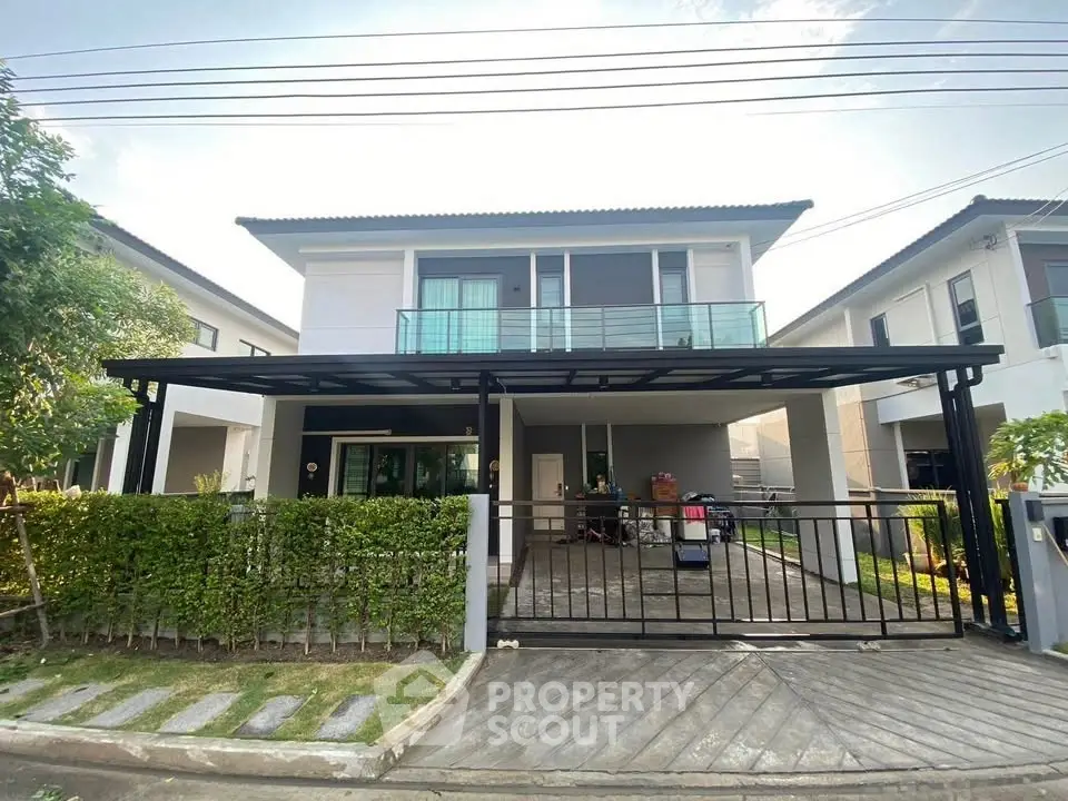 Modern two-story house with spacious driveway and sleek design in a suburban neighborhood.