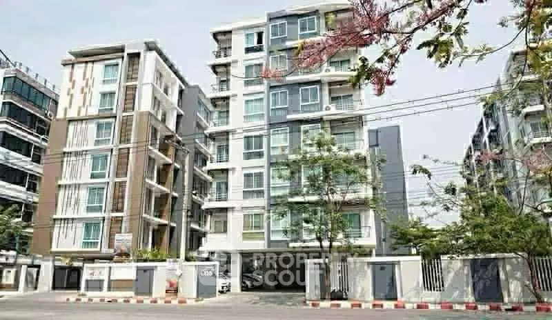 Modern apartment building with contemporary design and lush surroundings.