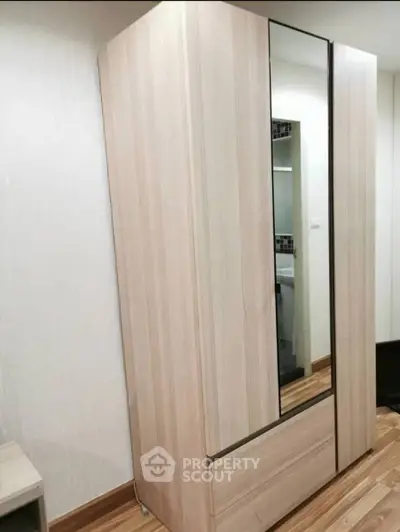 Modern wooden wardrobe in a stylish bedroom with sleek design and ample storage space.
