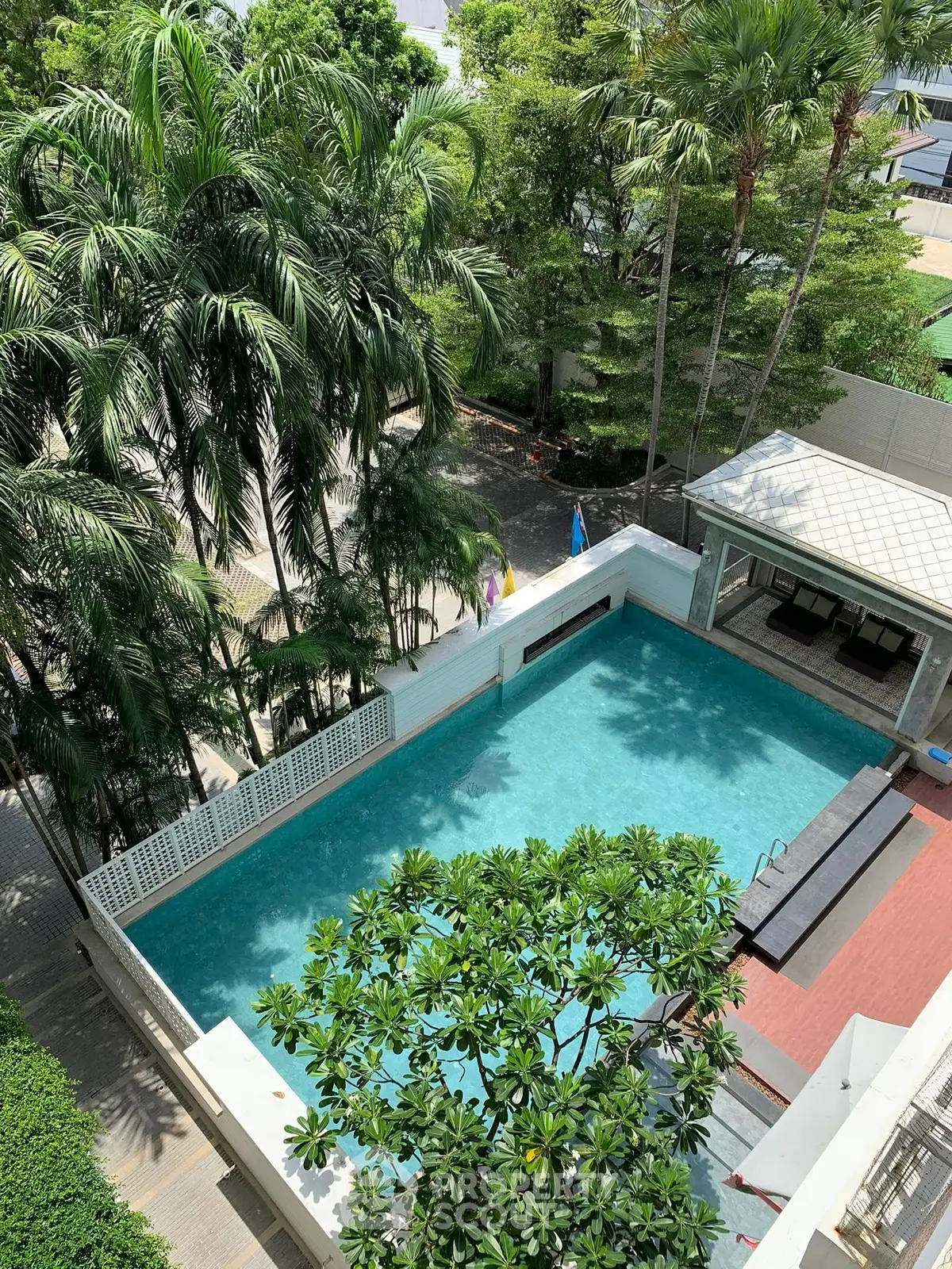 Luxurious residential pool surrounded by lush greenery and modern amenities.