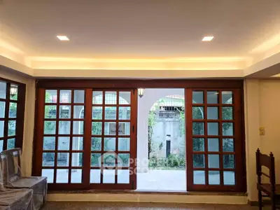 Spacious living room with large sliding glass doors opening to a serene garden view.