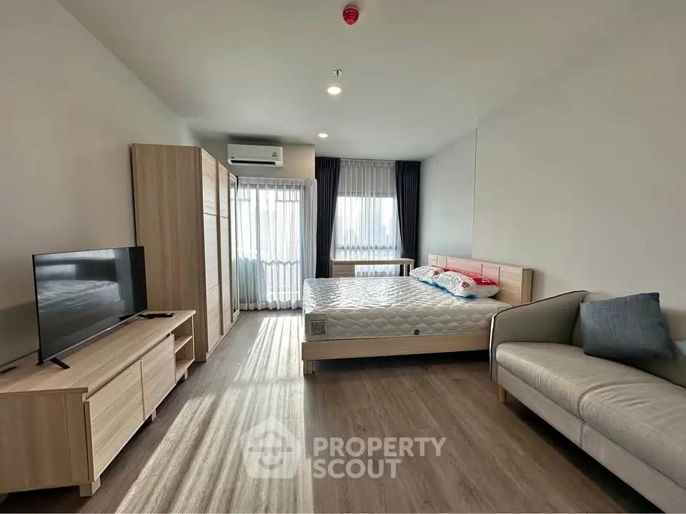 Spacious modern bedroom with natural light and stylish furnishings