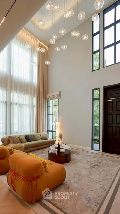 Luxurious high-ceiling living room with modern lighting and large windows