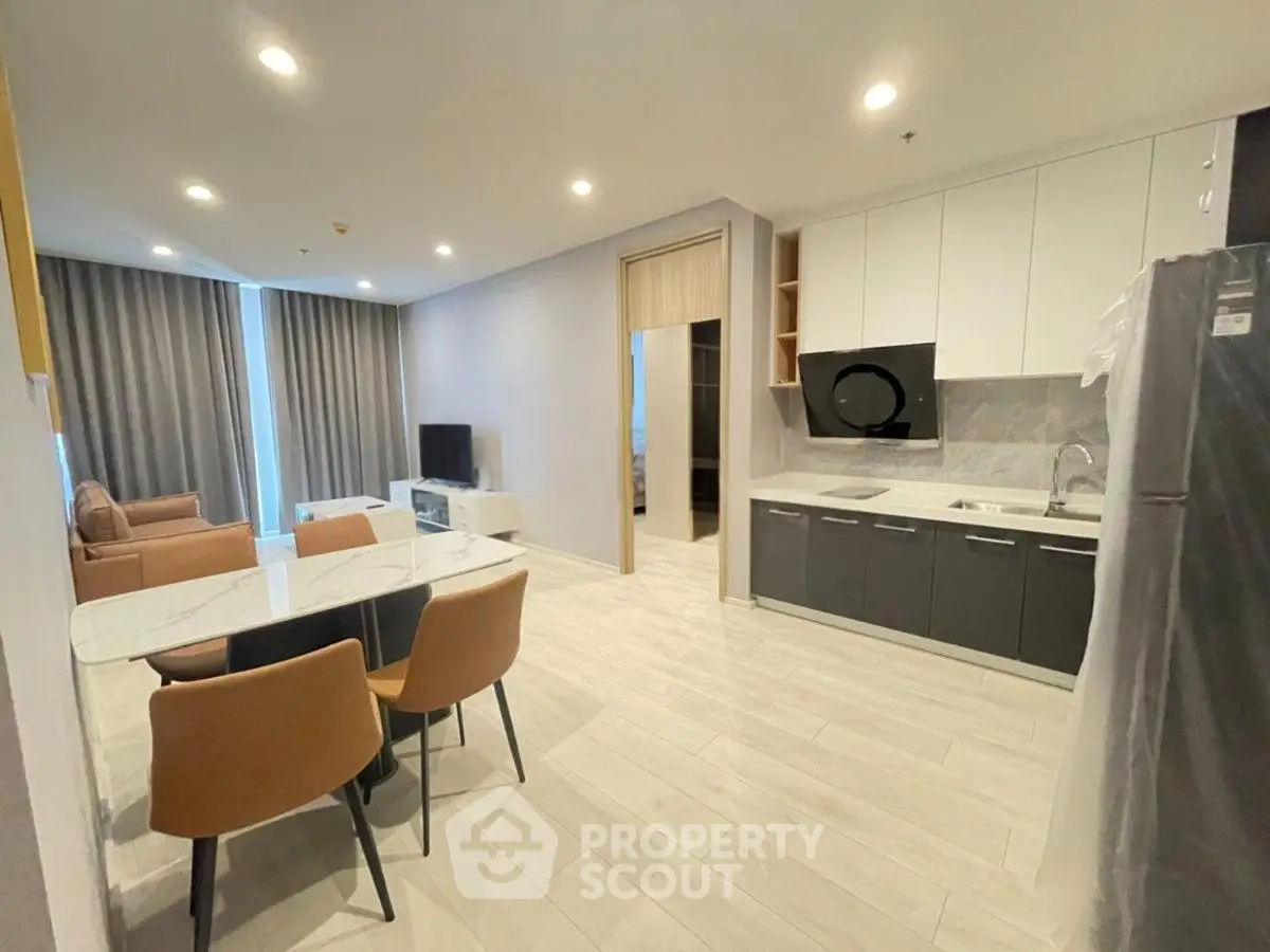 Modern open-layout living room and kitchen with sleek design and ample natural light.