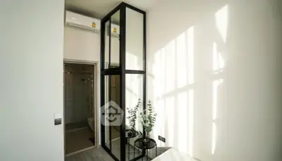 Modern bedroom with glass partition and natural light