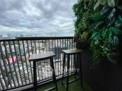 Stunning city view from a modern balcony with lush greenery and stylish seating.
